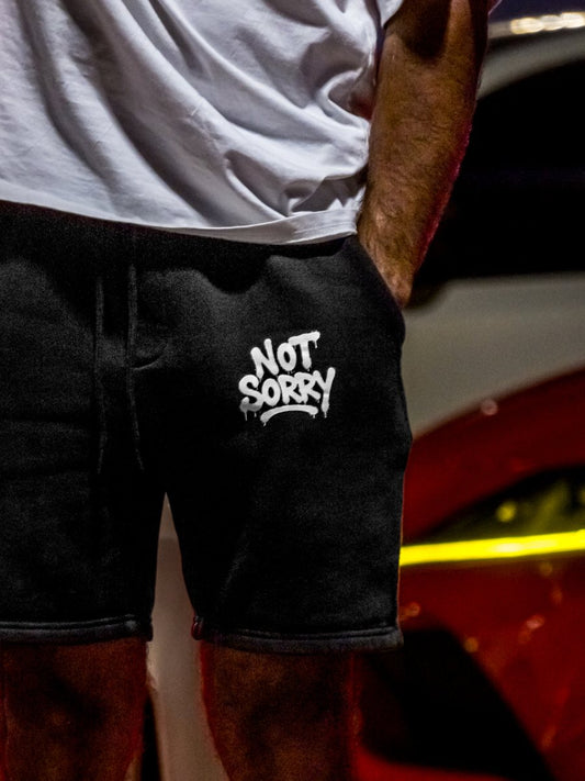 NOT SORRY shorts worn, front-leg logo